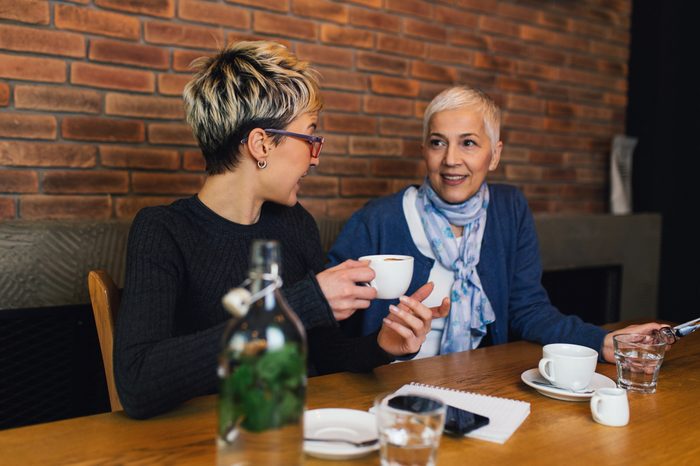 Senior mother sitting in cafe bar or restaurant with her middle age daughter and enjoying in conversation.