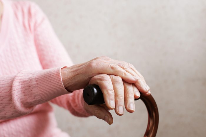 Hands of an old woman with a cane