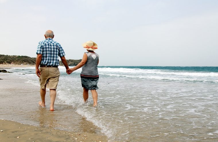 Happy senior couple walking together on a beach