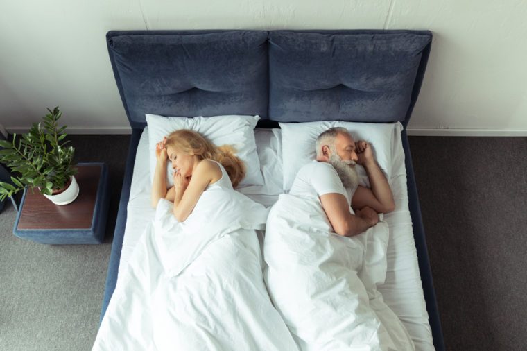 top view of couple sleeping back to back in bed