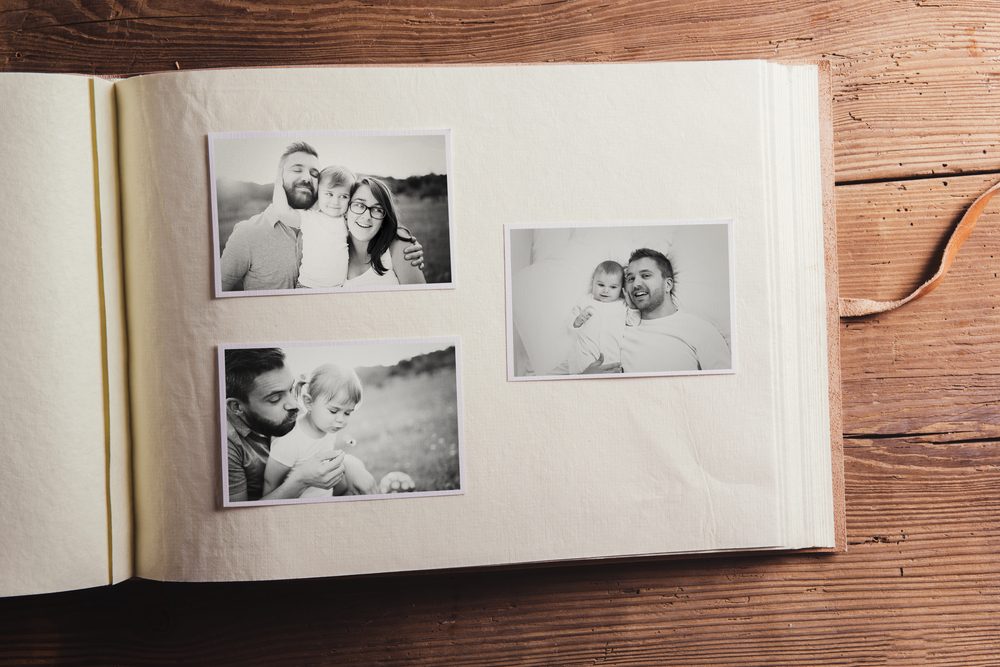 Fathers day composition - photo album with a black and white photos. Studio shot on wooden background.