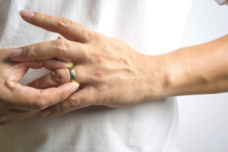 Man take off his wedding ring on white background