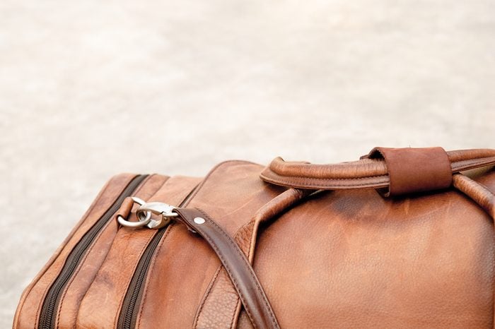 brown leather duffle bag on the floor