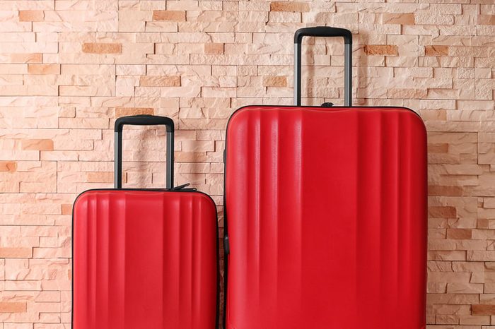 Red suitcases on brick wall background
