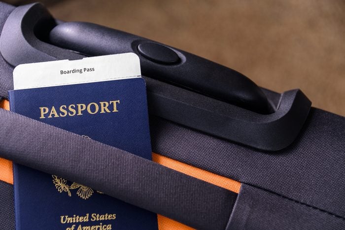 US passport and a boarding pass on a suitcase