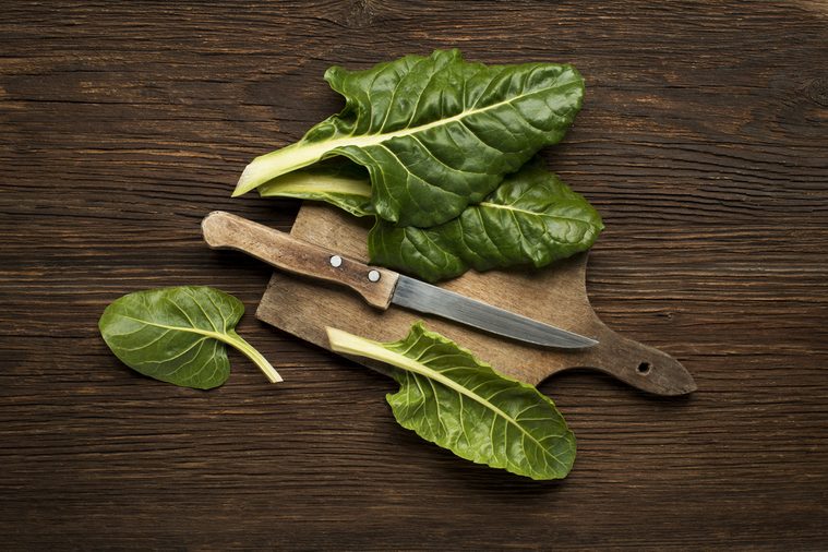 Fresh swiss chard leaves on a wooden background.