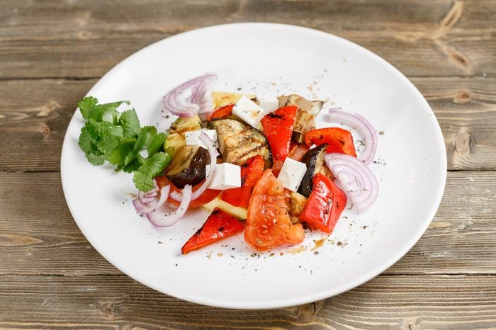 Grilled vegetables salad with red bell pepper, eggplant, onions, feta cheese, peppers, cilantro and tomato.