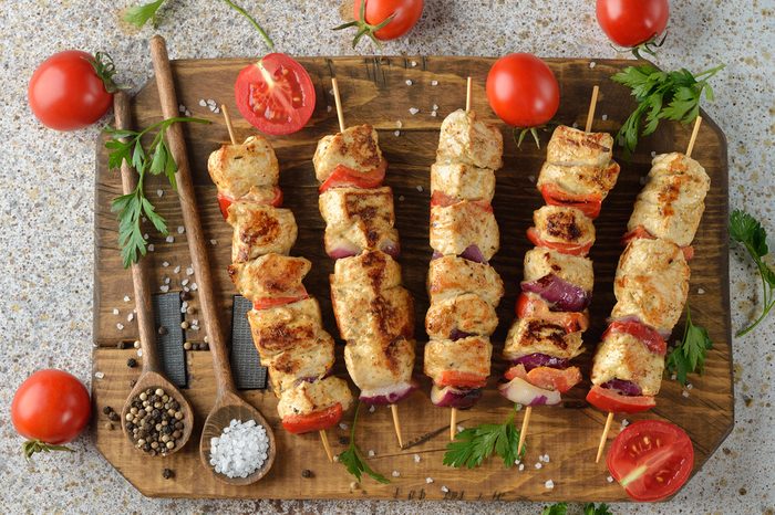 Kebabs with turkey fillet on a brown background