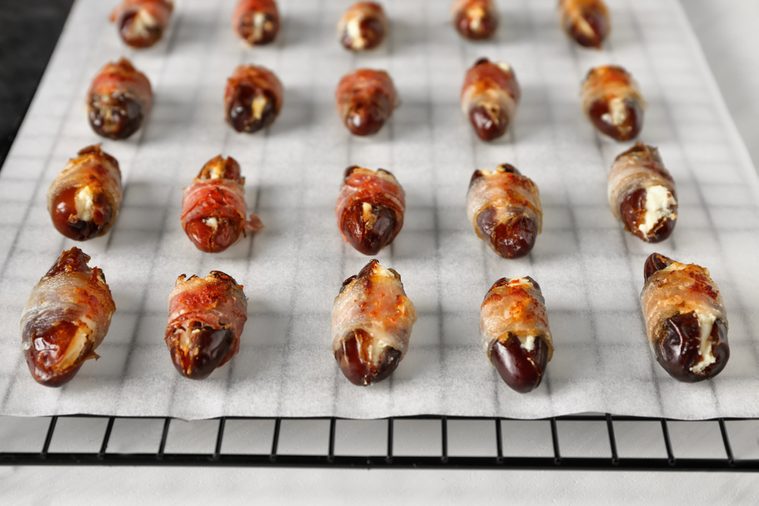 Bacon wrapped dates on baking rack, closeup