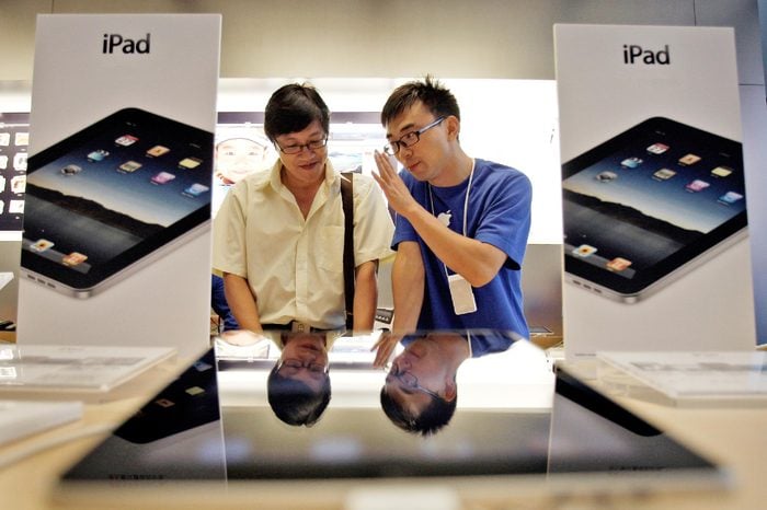 An employee of an Apple store introduces the Apple's iPad to a customer at the store during the launch of the device in Beijing