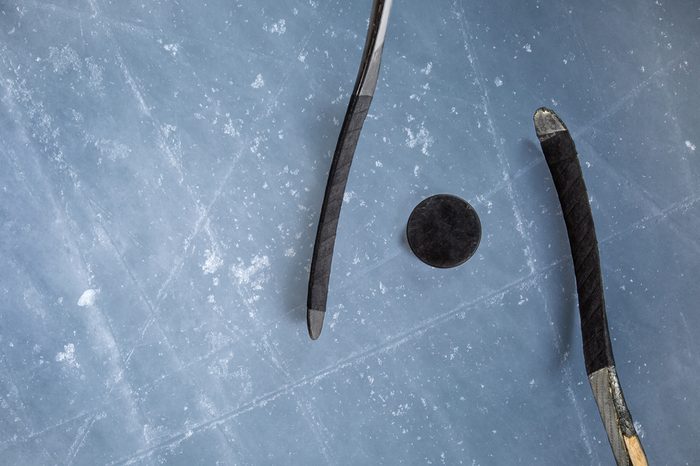 Ice hockey rink scratches surface for texture or background, winter closeup. puck two stick on ice background.