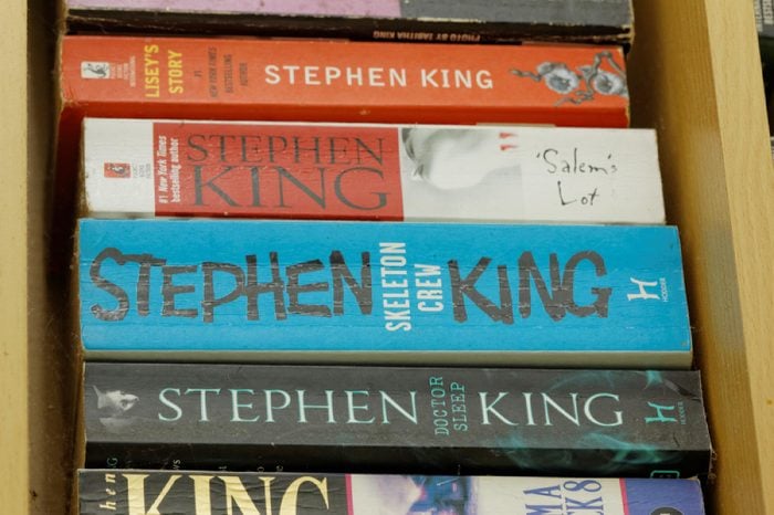 JOHOR,MALAYSIA - JULY 28, 2016: Assorted books written by famous thriller author Stephen King on display in wooden rack.