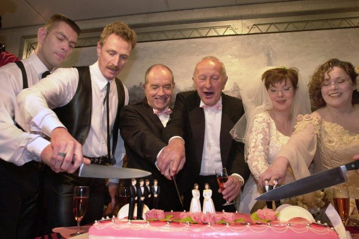 Peter Wittebrood-Lemke, Frank Wittebrood, Ton Jansen, Louis Rogmans, Helene Faasen and Anne-Marie Thus, left to right, cut the wedding cake after exchanging vows at Amsterdam's City Hall early . The pairs were among four gay couples to get married under a new law which took effect April 1, 2001, the world's first such law allowing same-sex marriages with equal rights