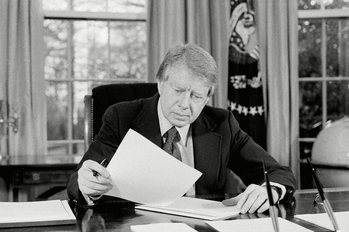 President Jimmy Carter ponders material in the Oval Office of the White House in Washington in preparation for his televised "fireside chat" with the nation later this evening