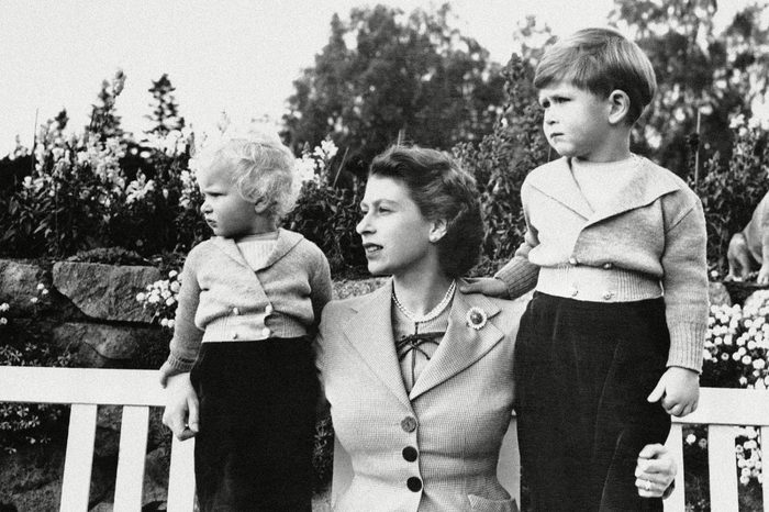 Queen Elizabeth II Prince Charles, four years old, is shown with his mother, Queen Elizabeth II, and sister, Princess Anne, on grounds of Balmoral Castle, Scotland, . Their interest is taken up with frolics of Royal household dogs