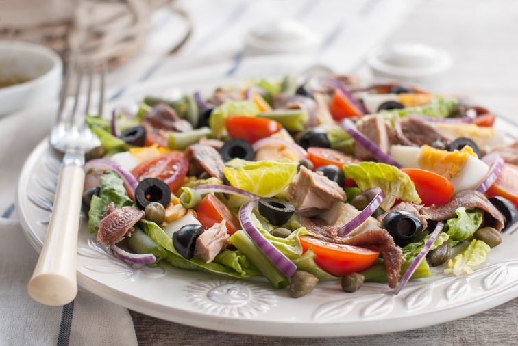 Nicoise salad. Nicoise salad with tuna, cherry tomatoes, eggs, lettuce, anchovy, red onion and capers. Food and drink.