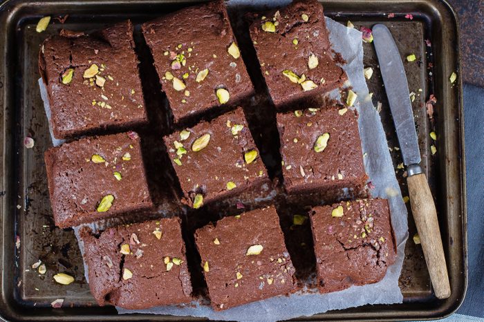 Homemade chocolate brownies with pistachios on dark background. Copy space, top view