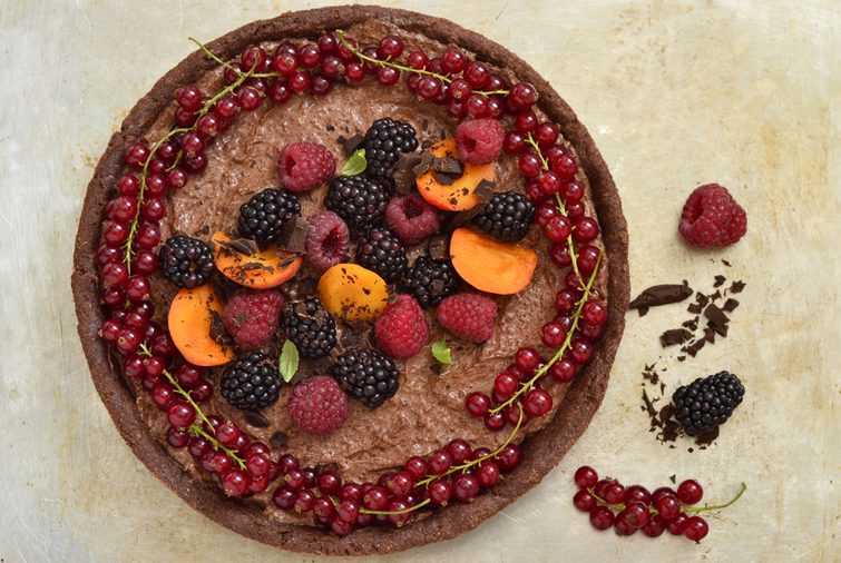Chocolate tart with chocolate cream and fresh berries, top view