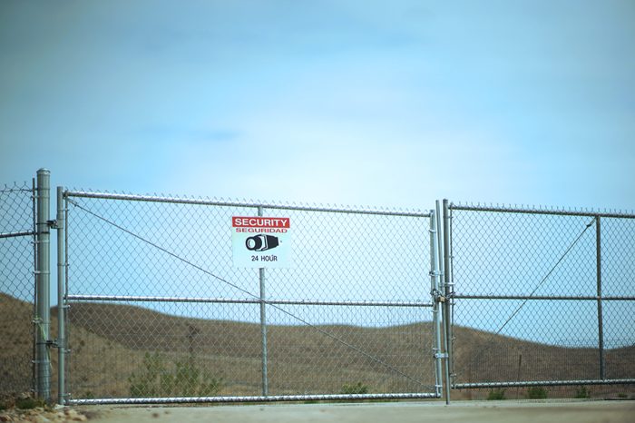 Warning Restricted Area Under Surveillance Sign On Gate