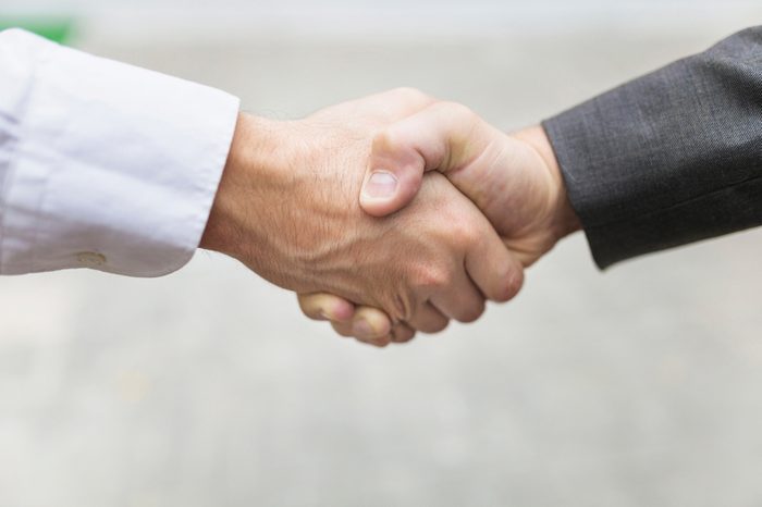 Closeup of two confident business man shaking hands 