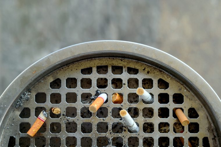 ashtray and cigarette with soft-focus and over light in the background. top view