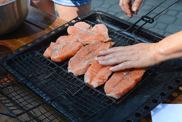 women's hands prepare raw steaks from salmon for grilling