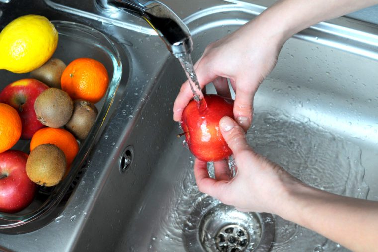 Women wash the apples in the kitchen.