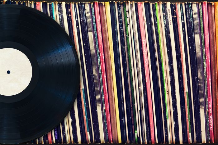 Vinyl record with copy space in front of a collection of albums (dummy titles), vintage process