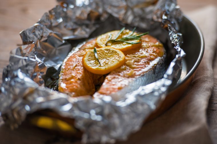 Salmon steak baked with lemon and herbs in foil