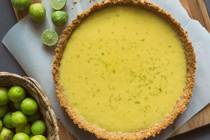 Key Lime Pie with a basket of limes. 