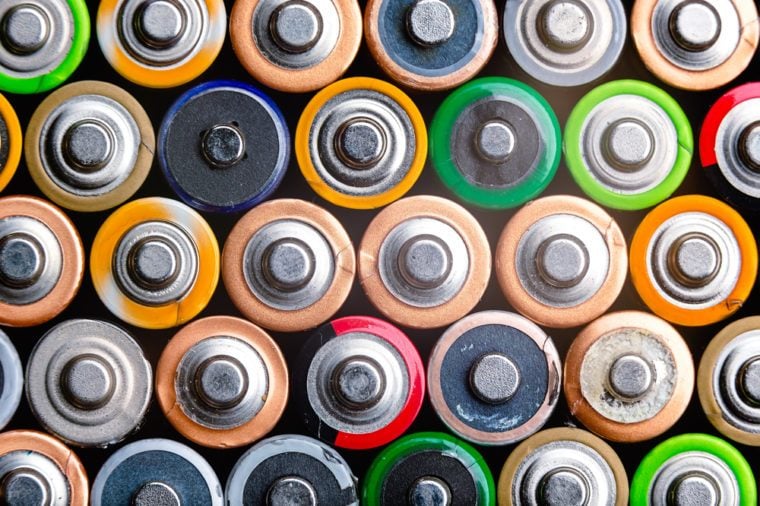 Energy abstract background of colorful batteries. Close up top view on rows of selection of AA batteries. Alkaline battery aa size. Several batteries are next to each other. Many aa batteries.