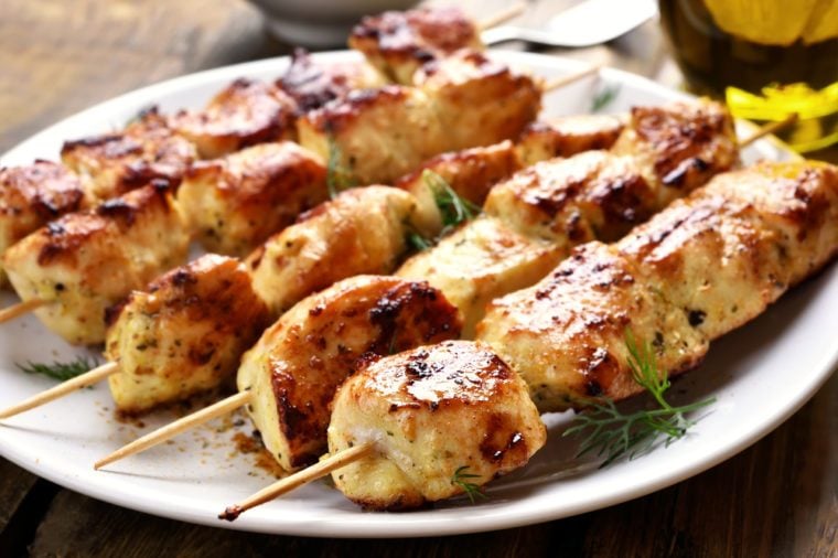 Grilled chicken on bamboo skewers, close up view