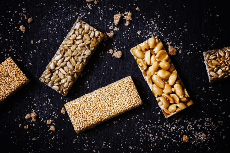 Sesame seeds, sunflower and peanuts in caramel, dark food background, selective focus
