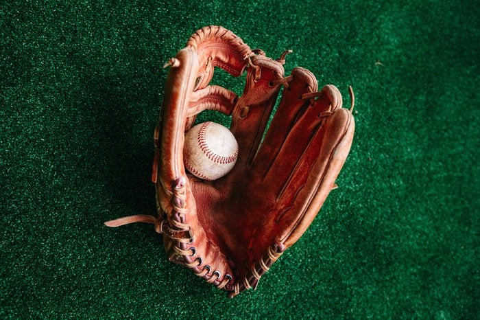 The old leather glove of the baseball catcher and the ball
