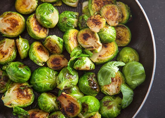 Fresh fried brussel sprouts in a black frying pan