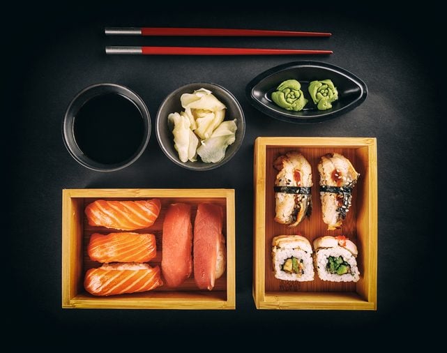 Sushi Set: sushi and sushi rolls on black background, top view