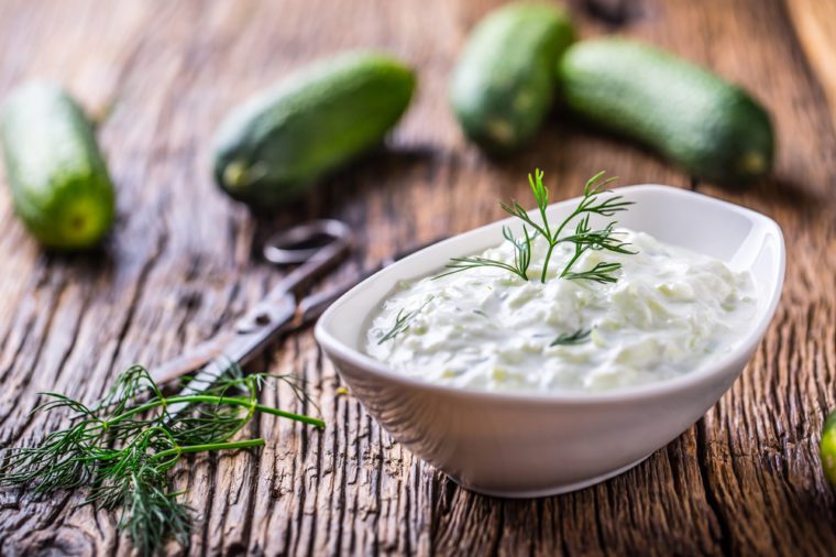 Traditional greek dip sauce or dressing tzatziki prepared with grated cucumber sour cream yogurt olive oil and fresh dill. 