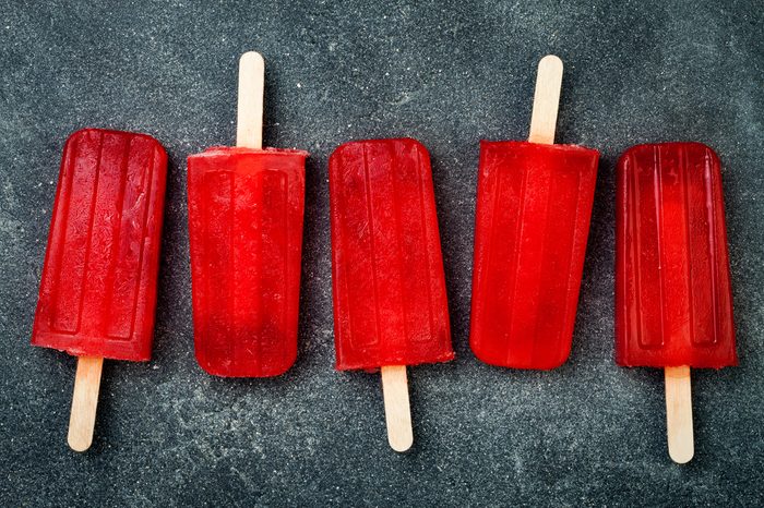 Homemade frozen blood orange natural juice alcoholic popsicles - paletas - ice pops. Overhead, flat lay, top view. Halloween party recipe idea
