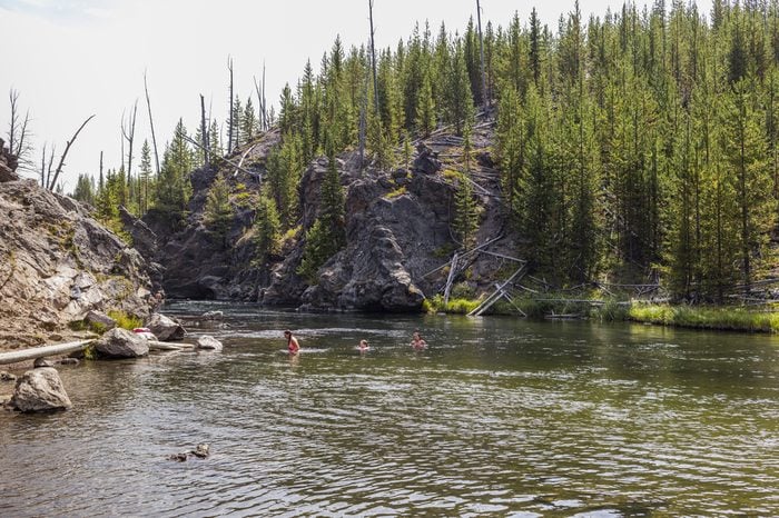 People swimming in the Firehole River.