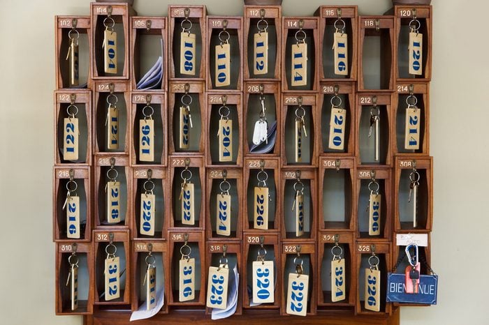 Hotel keys with room numbers hanging at reception desk counter