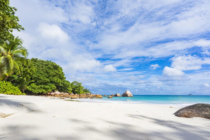 Turquoise water, granite rocks and palm trees in the white sand on the paradise beach at anse lazio on the seychelles