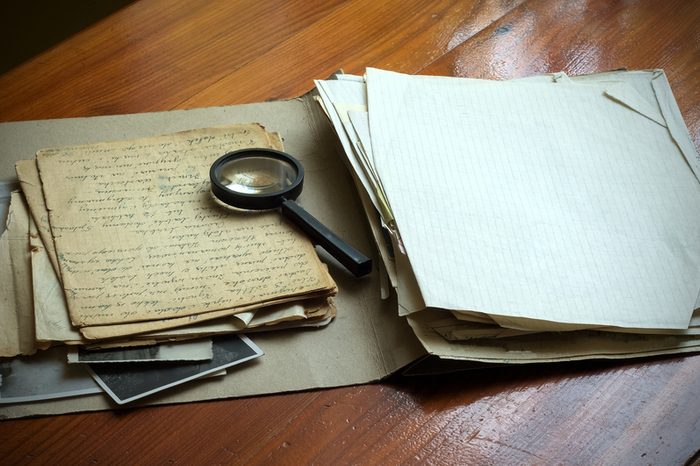 Vintage documents with magnifying glass investigation concept