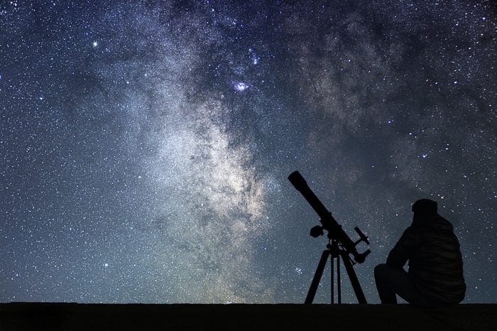 Man with astronomy telescope looking at the stars. Man telescope and starry sky. Night sky. Milky way galaxy.