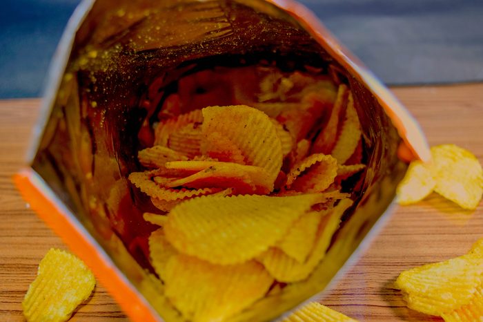 Potato chips in bag And outside the bag On a wooden table