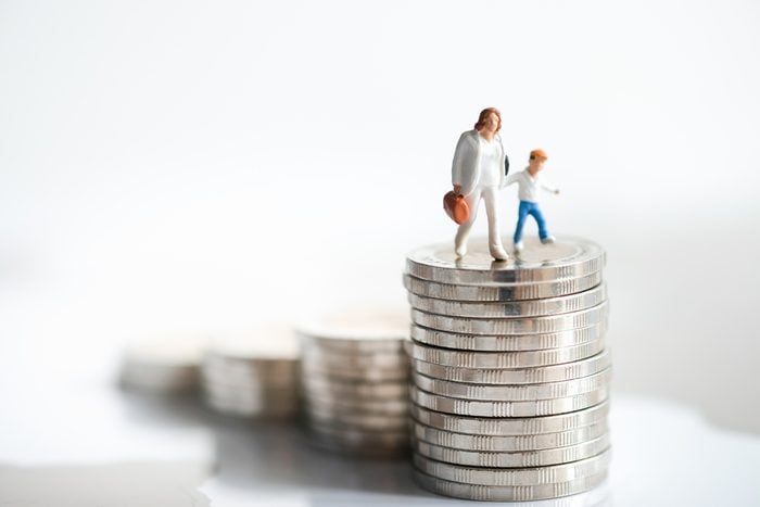 Miniature people: Woman and child standing on rows of stack coins using as background Money, Financial, Business Growth and family concept,