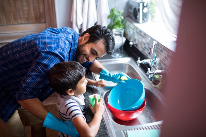 High angle view of father and son cleaning utensils at home