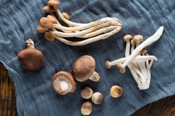 A combination of straw mushroom, tea mushroom, shiitake mushrooms, etc. on a wooden board, gauze for background