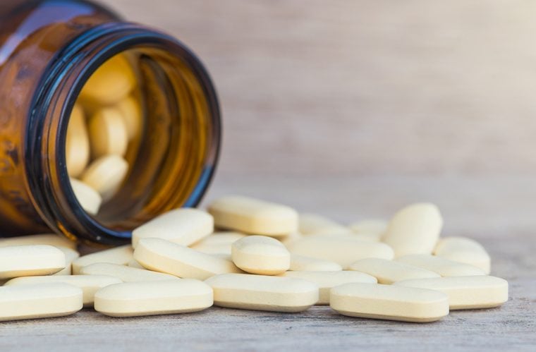 Pills or vitamin in Medicine bottles on wood background
