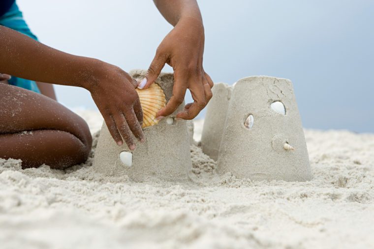 Mother and child putting a shell on a sandcastle