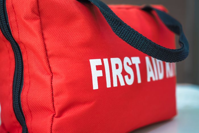 First Aid KitA red first aid kit bag with a black zip and handle, in closeup.